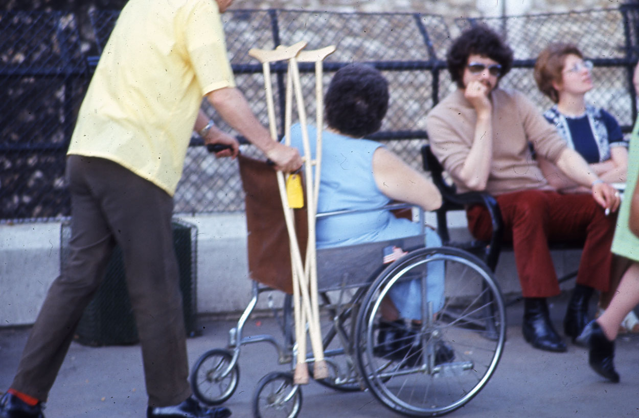 Wheelchair and crutches on the pavement.